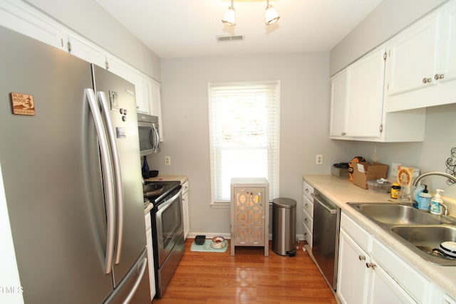 kitchen featuring white cabinetry, stainless steel appliances, dark wood-type flooring, and sink