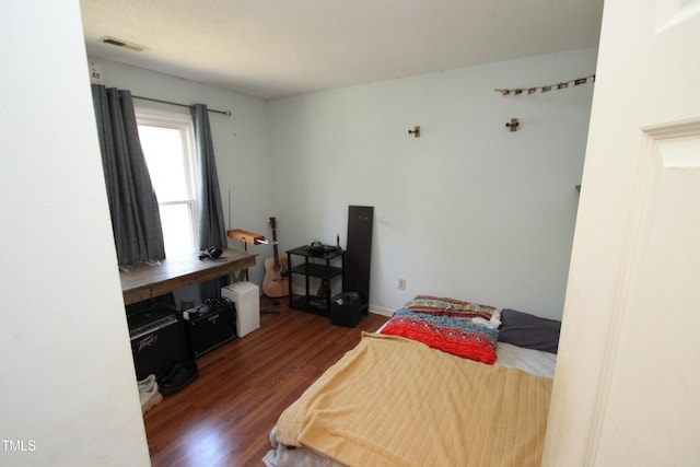 bedroom with dark hardwood / wood-style flooring