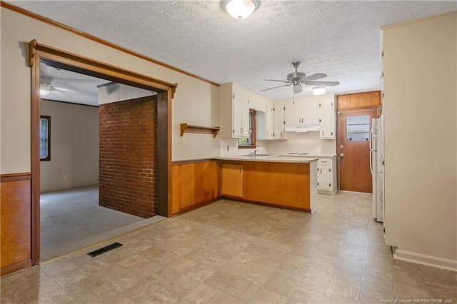 kitchen with white cabinetry, a textured ceiling, kitchen peninsula, and white refrigerator