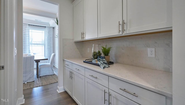 kitchen featuring white cabinets, light stone countertops, backsplash, and dark hardwood / wood-style flooring