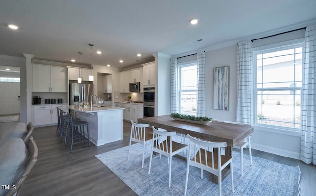 dining space with a wealth of natural light and dark hardwood / wood-style floors