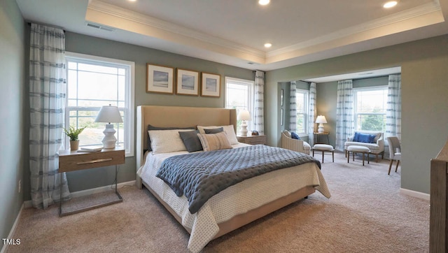 carpeted bedroom with ornamental molding and a tray ceiling