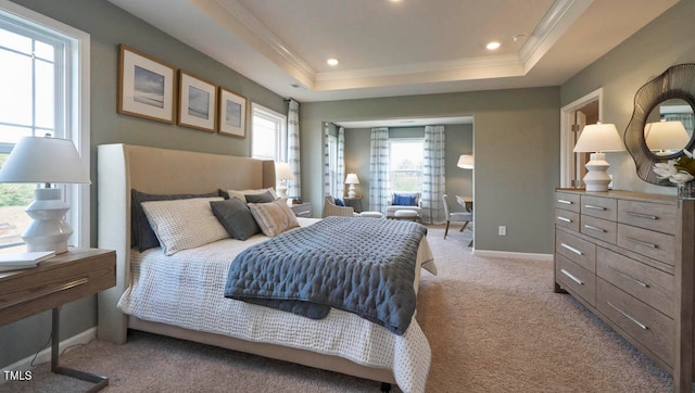 bedroom featuring ornamental molding, light carpet, and a tray ceiling