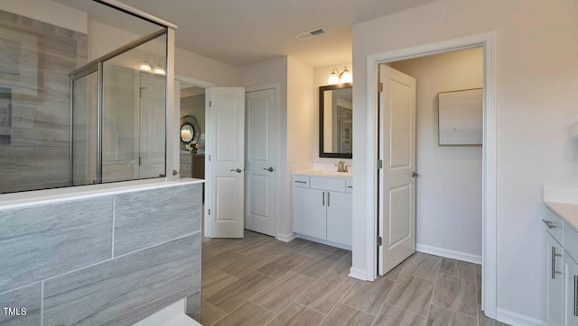 bathroom featuring vanity and a shower with shower door