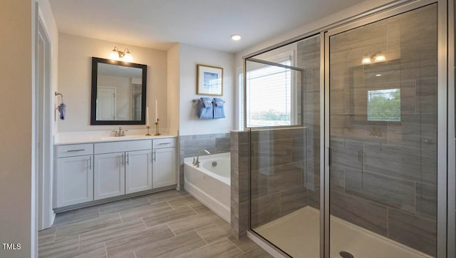 bathroom with vanity and shower with separate bathtub