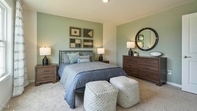 bedroom with light carpet and multiple windows