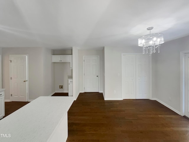 interior space featuring an inviting chandelier and dark wood-type flooring