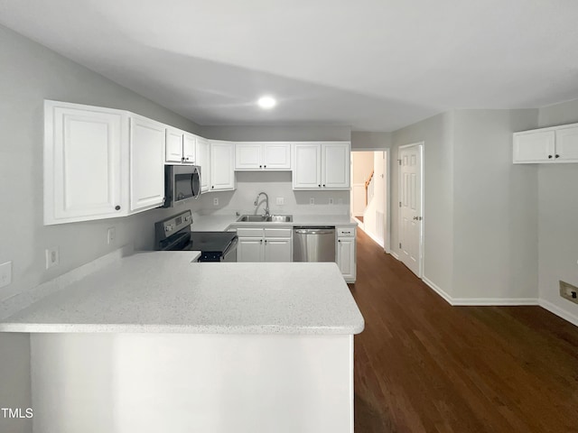 kitchen featuring kitchen peninsula, dark hardwood / wood-style flooring, white cabinetry, sink, and stainless steel appliances