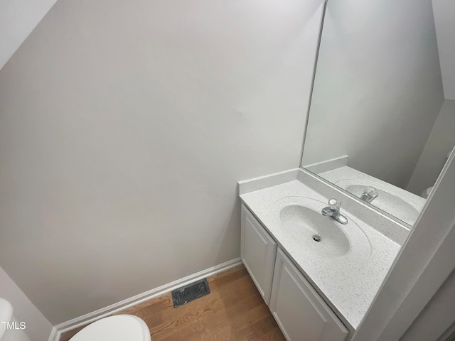 bathroom featuring vanity, toilet, and hardwood / wood-style floors