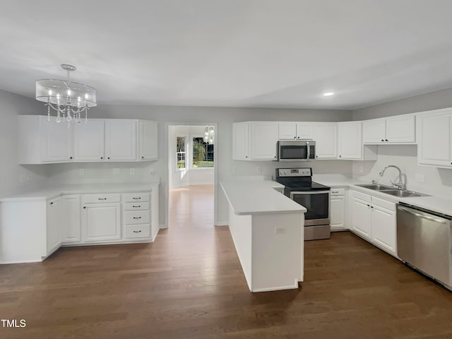 kitchen with sink, appliances with stainless steel finishes, pendant lighting, and white cabinetry