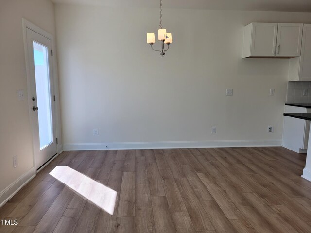 3616 Tarmac Rd Unit Ep 129, Wilson, NC 27896 - unfurnished dining area with a chandelier, wood finished floors, and baseboards