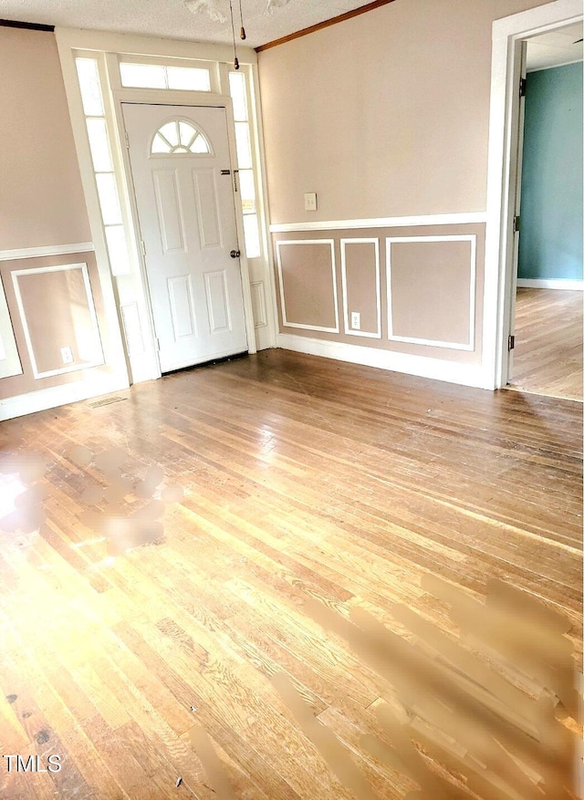 foyer entrance featuring wood-type flooring and a textured ceiling