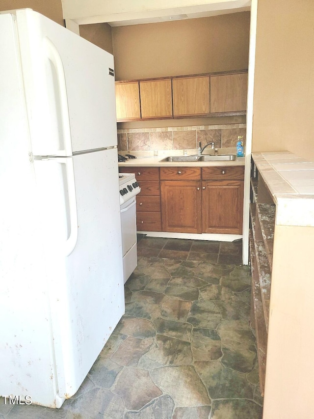 kitchen with tasteful backsplash, white appliances, and sink