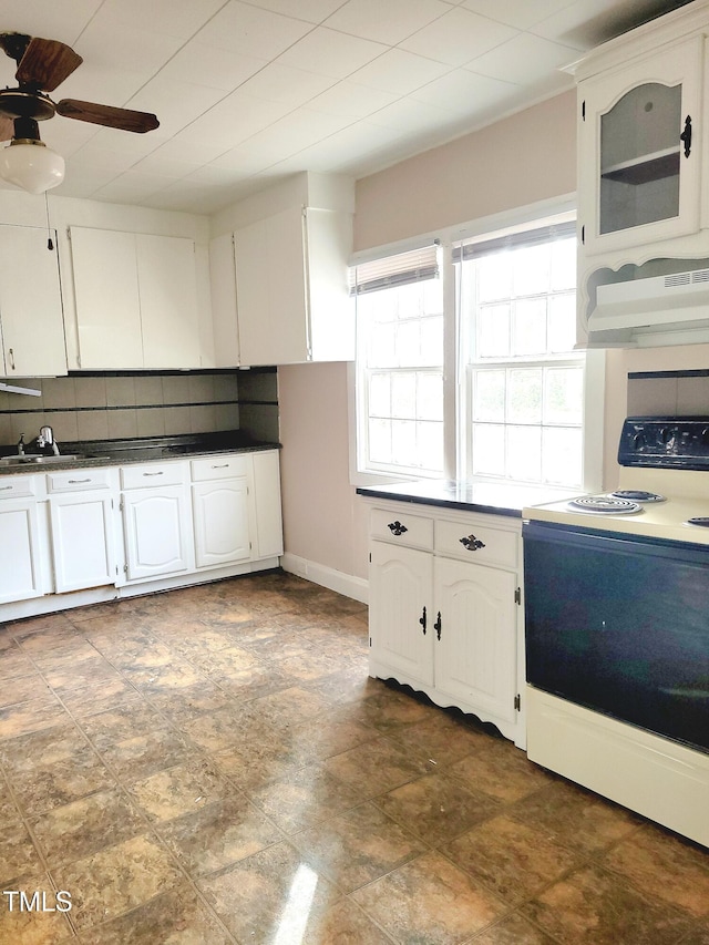 kitchen featuring ceiling fan, electric range, white cabinets, decorative backsplash, and exhaust hood