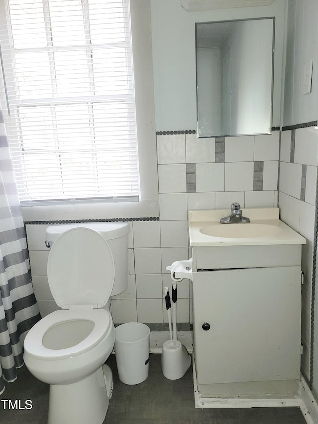 bathroom with tile walls, vanity, and toilet