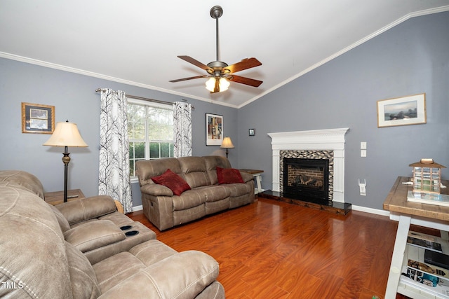 living room with wood-type flooring, vaulted ceiling, ornamental molding, and a fireplace