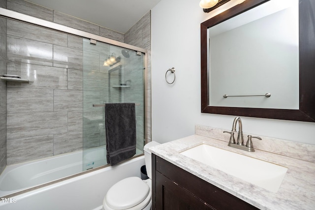 full bathroom featuring vanity, shower / bath combination with glass door, and toilet