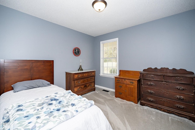 bedroom featuring light colored carpet and a textured ceiling