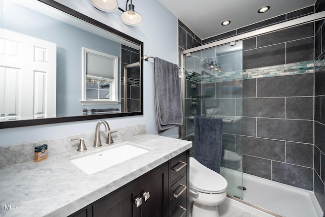 bathroom featuring vanity, toilet, and an enclosed shower