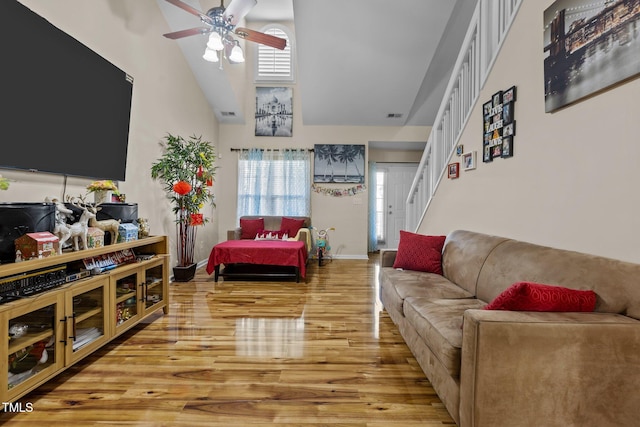 living room featuring high vaulted ceiling, light wood-type flooring, and ceiling fan