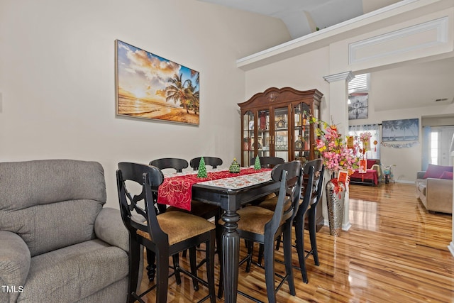 dining area featuring hardwood / wood-style floors and a high ceiling