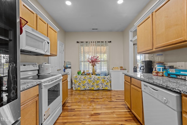 kitchen featuring white appliances, light brown cabinetry, light stone countertops, and light wood-type flooring