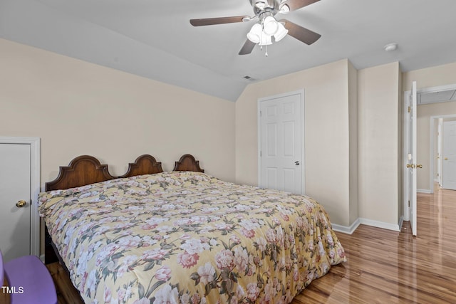 bedroom featuring hardwood / wood-style flooring, vaulted ceiling, and ceiling fan