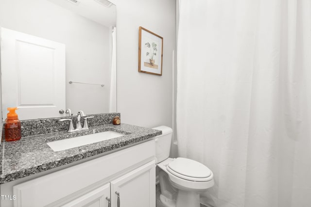 bathroom featuring vanity, toilet, and walk in shower