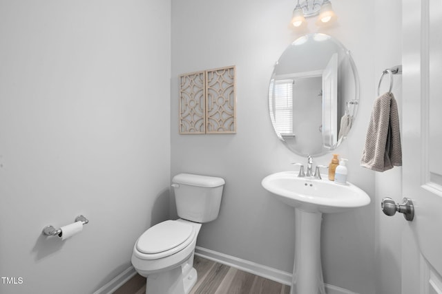 bathroom with sink, hardwood / wood-style floors, a notable chandelier, and toilet