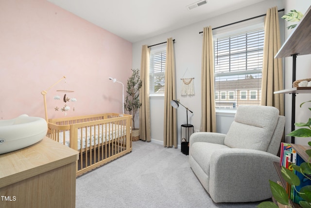 bedroom with light carpet and a nursery area