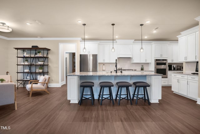 kitchen with stainless steel appliances, an island with sink, dark hardwood / wood-style floors, and hanging light fixtures