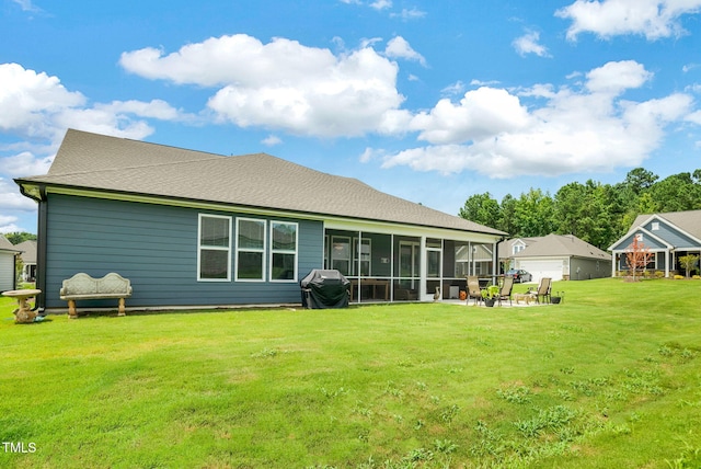 rear view of property featuring a yard, a sunroom, and a patio area