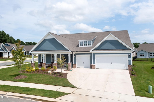 craftsman inspired home featuring a front yard, a porch, and a garage