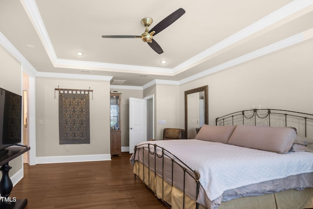 bedroom with crown molding, dark wood-type flooring, a raised ceiling, and ceiling fan