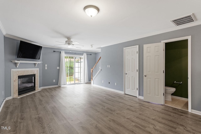 unfurnished living room with ceiling fan, wood-type flooring, and ornamental molding