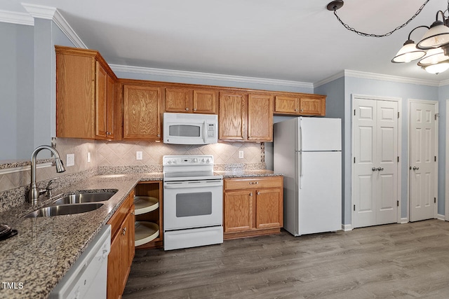 kitchen with ornamental molding, wood-type flooring, sink, and white appliances