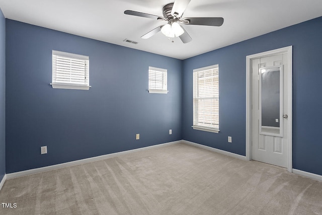 carpeted spare room featuring ceiling fan