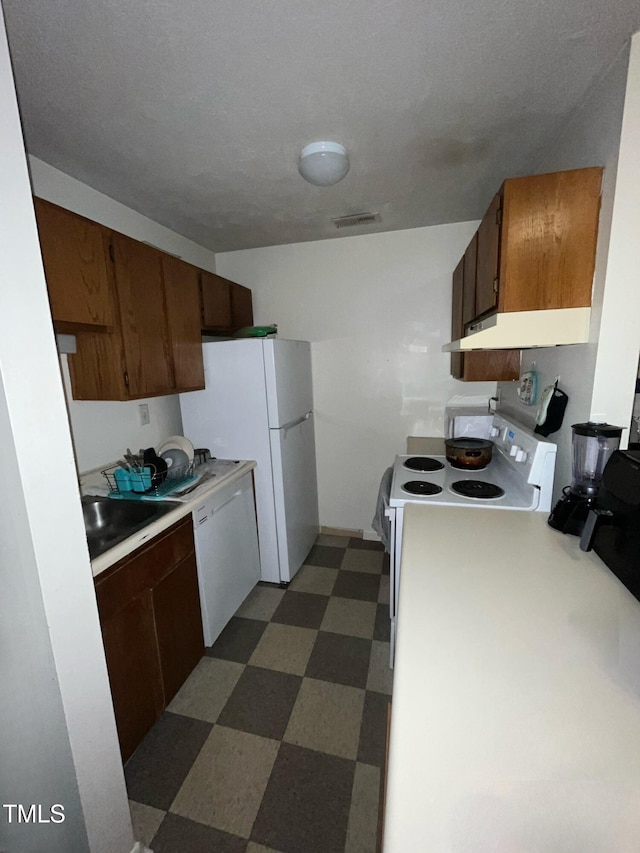 kitchen with white appliances, a textured ceiling, and sink