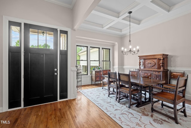 dining space featuring ornamental molding, light hardwood / wood-style flooring, an inviting chandelier, and plenty of natural light