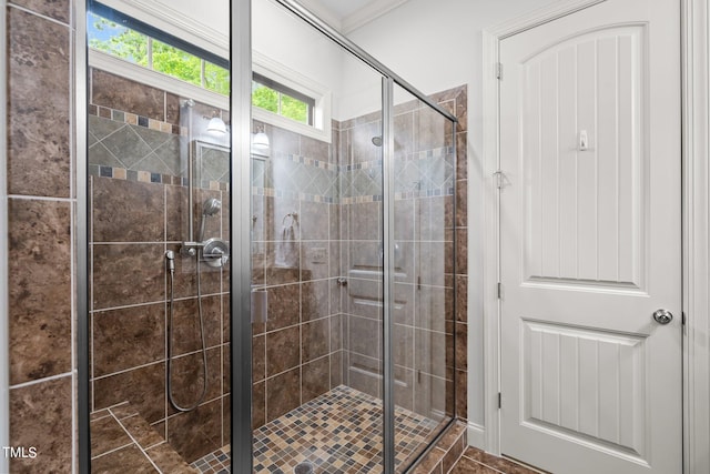 bathroom featuring a shower with door and crown molding