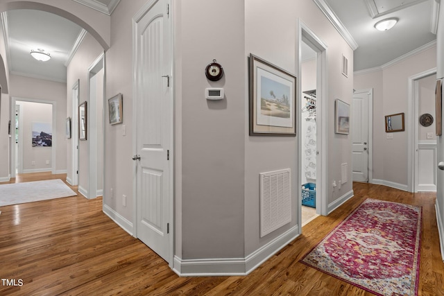 hall with hardwood / wood-style flooring and ornamental molding