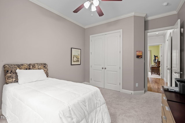 bedroom featuring a closet, ceiling fan, carpet flooring, and ornamental molding