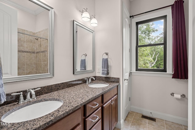 bathroom featuring vanity, a tile shower, and tile patterned floors