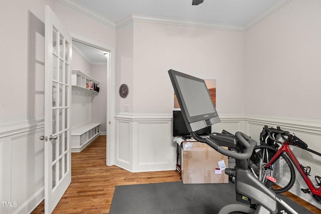 workout room featuring crown molding and light hardwood / wood-style flooring