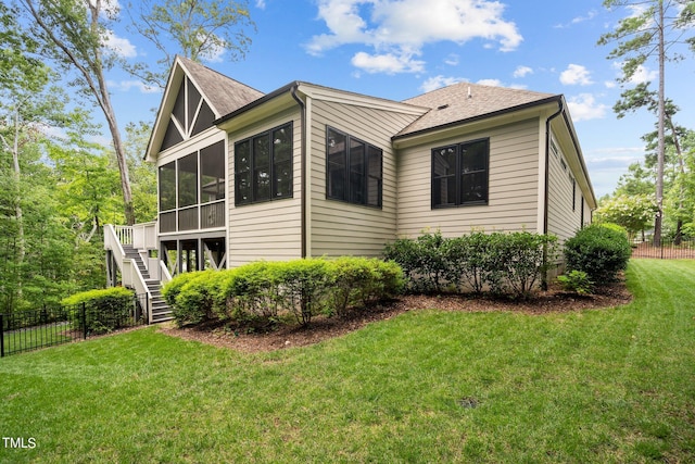 view of side of property featuring a yard and a sunroom