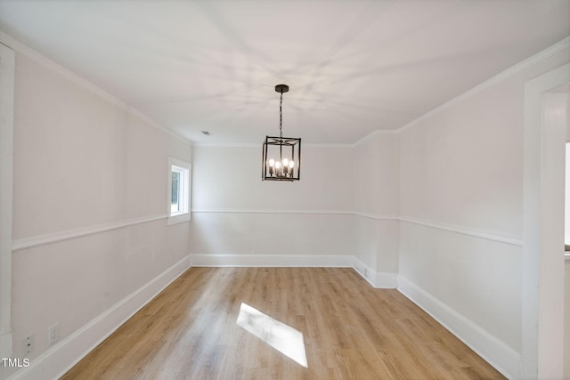 unfurnished dining area featuring a notable chandelier, ornamental molding, and light wood-type flooring