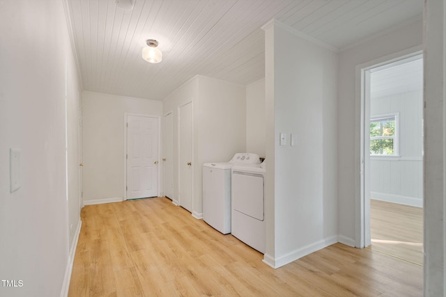 clothes washing area with ornamental molding, wood ceiling, washing machine and clothes dryer, and light hardwood / wood-style floors