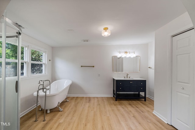 bathroom with vanity, a tub to relax in, and hardwood / wood-style flooring