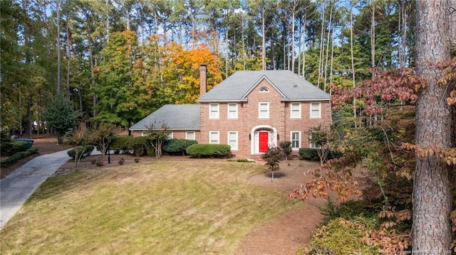 colonial-style house featuring a front yard