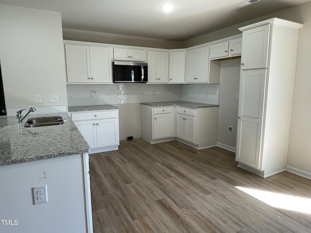 108 Pate Landing Dr, Selma, NC 27576 - kitchen with light stone countertops, white cabinets, wood finished floors, stainless steel microwave, and a sink
